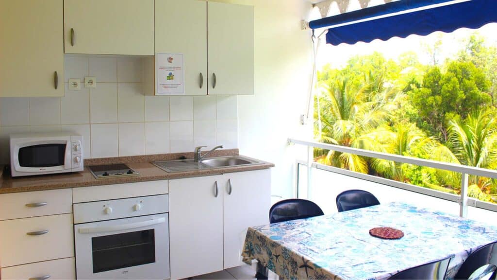 Outdoor kitchen and balcony dining area in a superior studio at les Cayalines with garden views