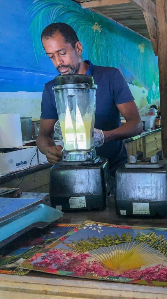 Local vendor freshly blending fruit drinks at an open air stand in Martinique France