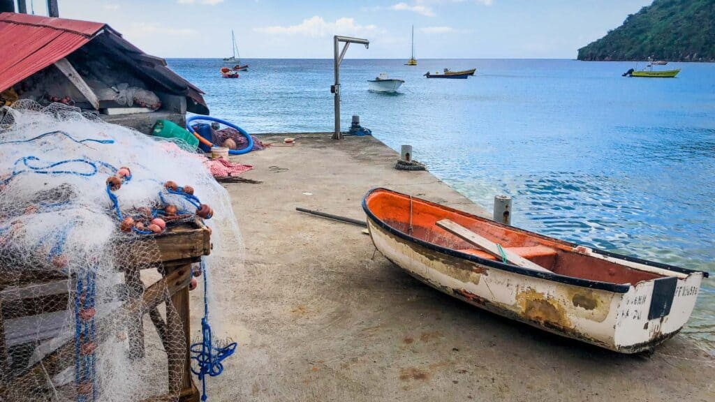 Fishing nets and weathered wooden boats at a Martinique travel guide waterfront village dock