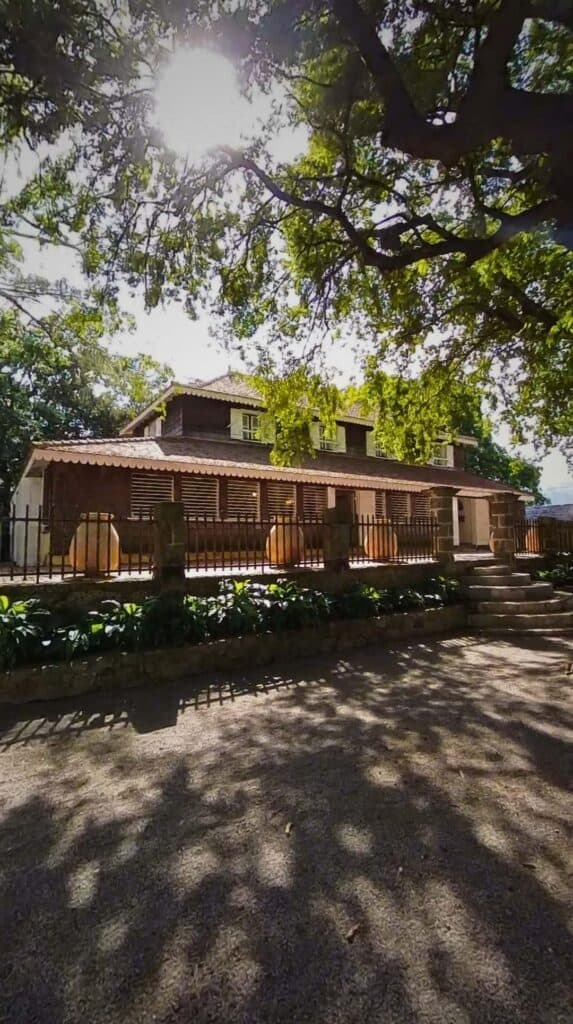 Historic colonial building shaded by large trees on a food and culture tour in Martinique
