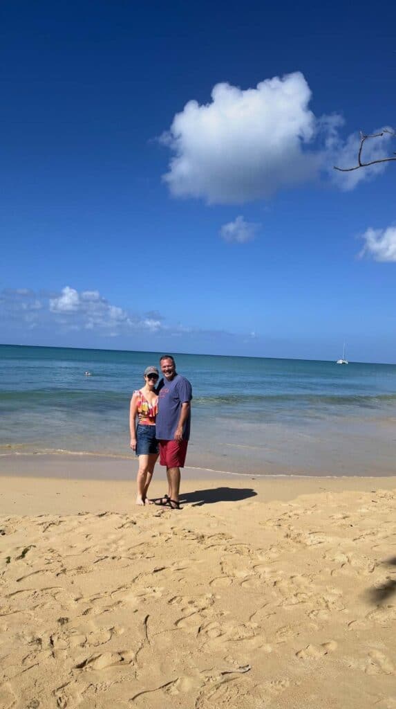 Couple posing on a sandy beach at Grande Anse d'Arlet before a scuba diving tour in Martinique
