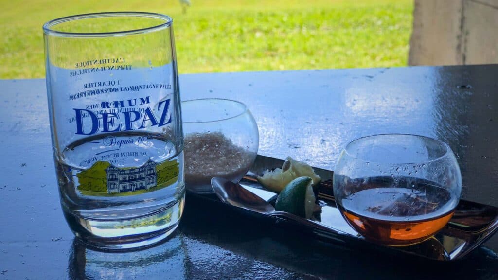 Ti Punch Martinique served in a branded Depaz Distillery glass with lime and brown sugar on a dark table