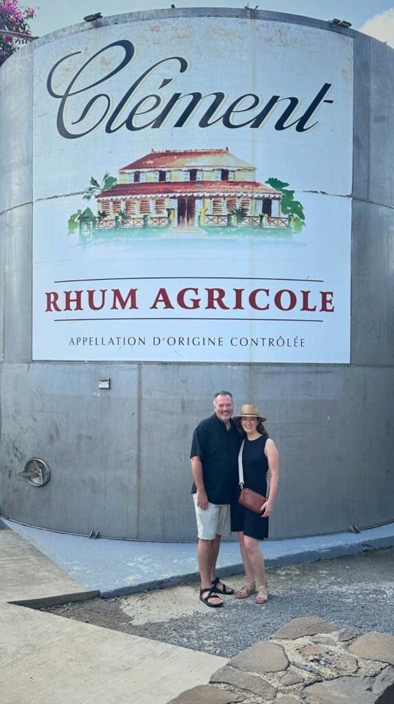 Couple posing in front of a large Clément Rhum Agricole distillery tank in Martinique France