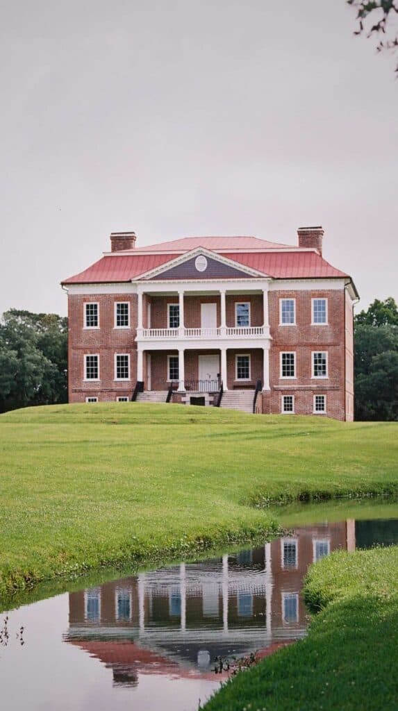 Drayton Hall reflected in a still pond on the grounds, a scenic stop on a romantic Charleston getaway

