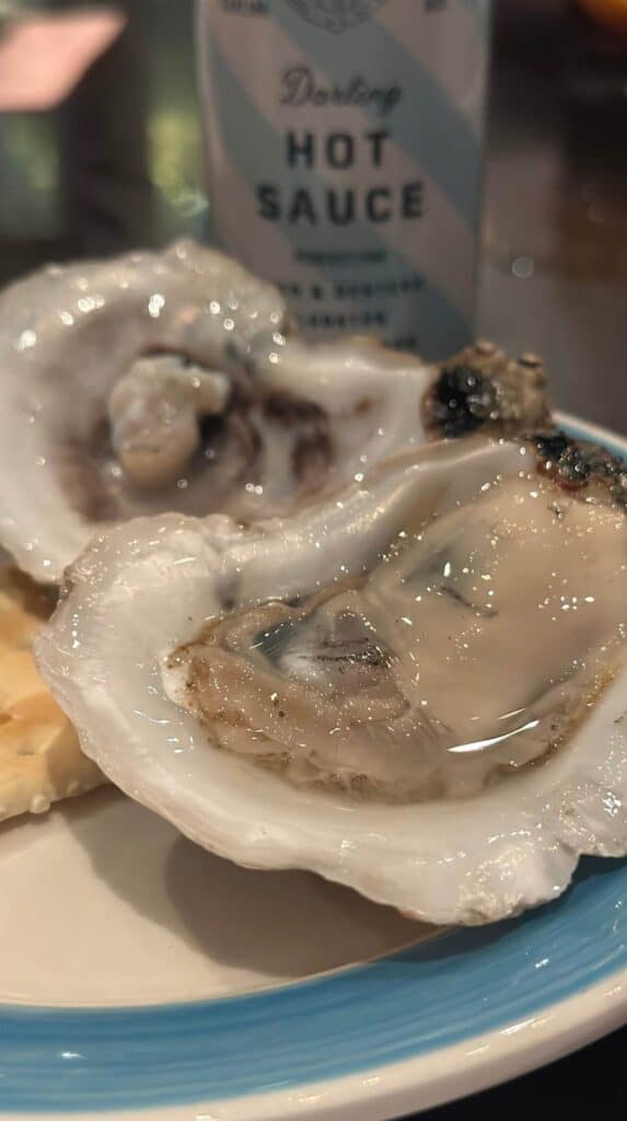 Fresh raw oysters on the half shell with hot sauce, a must for date ideas in Charleston
