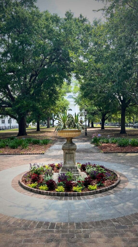 Garden fountain surrounded by flowers and oak trees in downtown Charleston, perfect for a romantic Charleston getaway
