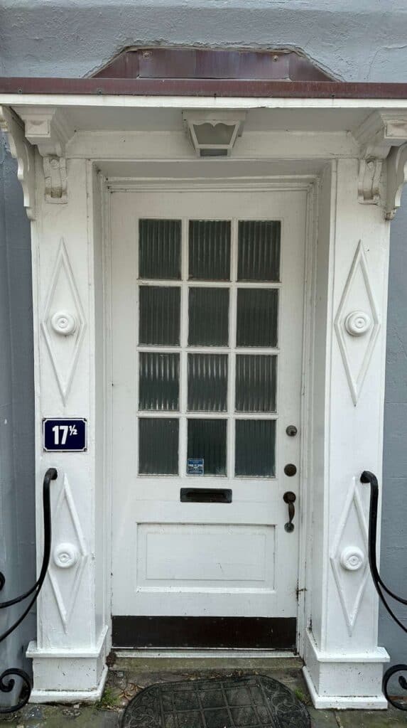 White single house door marked 17&frac12; with diamond detailing, a fun find for couples exploring Charleston
