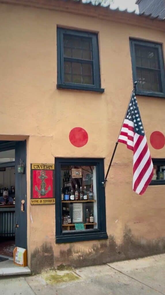 The Tavern at Rainbow Row storefront with an American flag, a great stop for date ideas in Charleston
