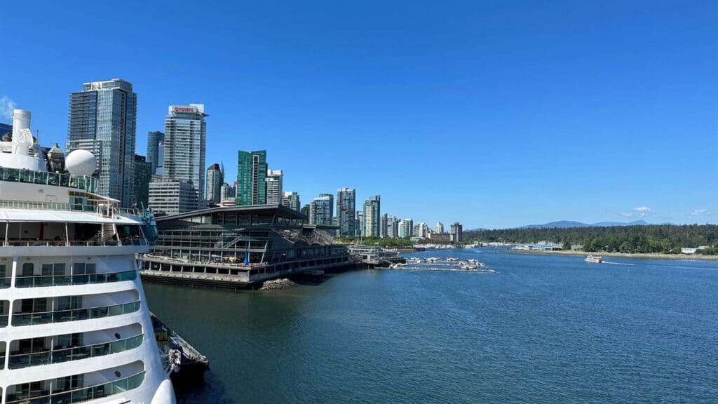 Vancouver waterfront with cruise ships docked at Canada Place and city skyline behind, showing the cruise port destination.