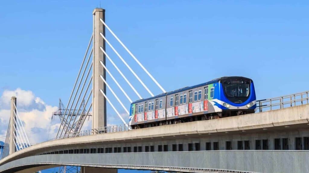 Vancouver SkyTrain crossing an elevated bridge under a clear blue sky, a budget friendly option from vancouver airport to cruise port.