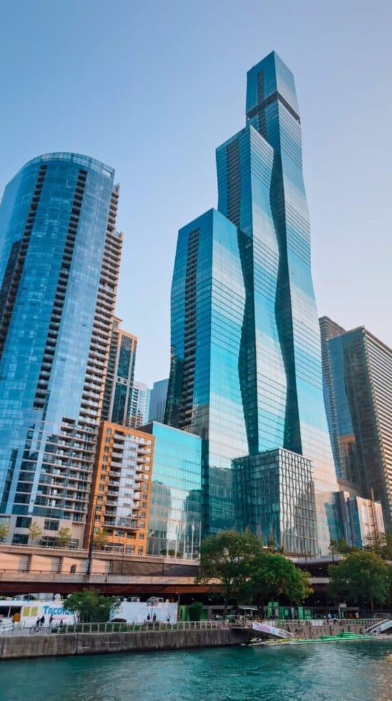 Glass skyscrapers rising above the Chicago River on a chicago architecture boat tour at dusk