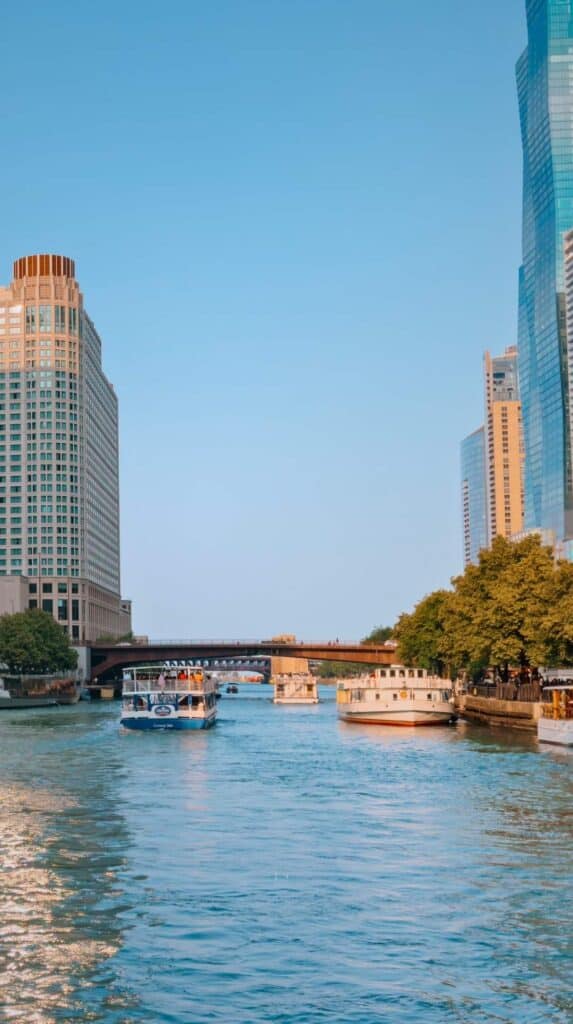 Skyscrapers towering over a passing boat on a chicago architecture boat tour morning