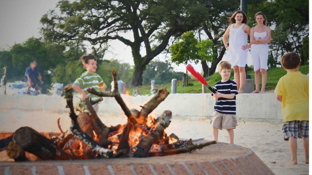 Sunset over Front Beach in Ocean Springs with a fire pit set up on the sand, a relaxing evening activity and one of the best things to do in Ocean Springs.