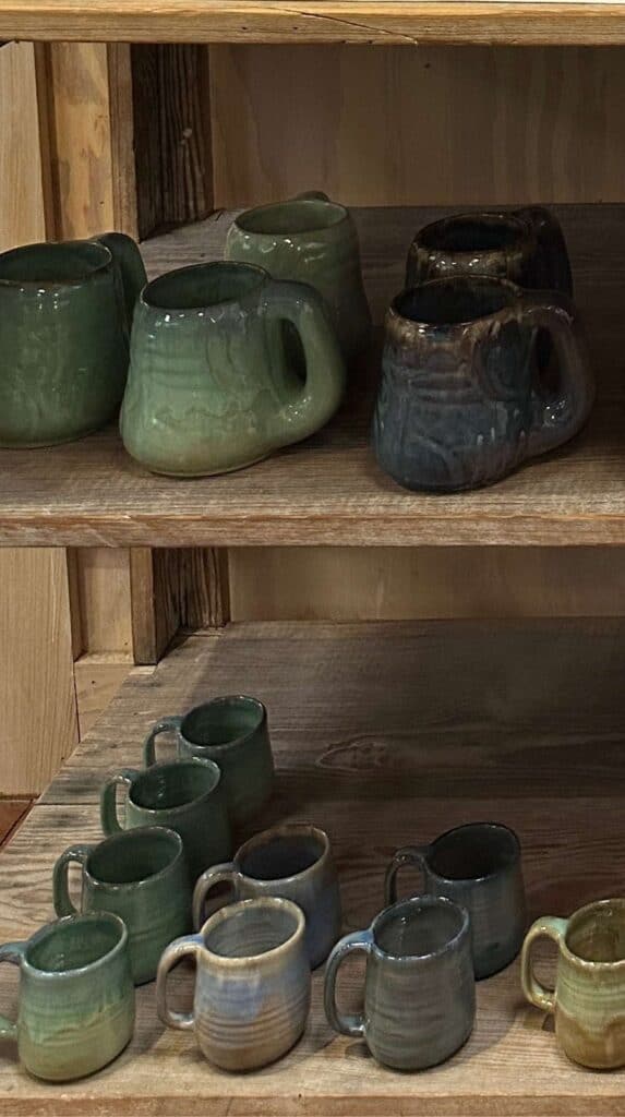 Interior of a pottery showroom filled with shelves of bowls, mugs, and decorative ceramics at Shearwater Pottery in Ocean Springs Mississippi.