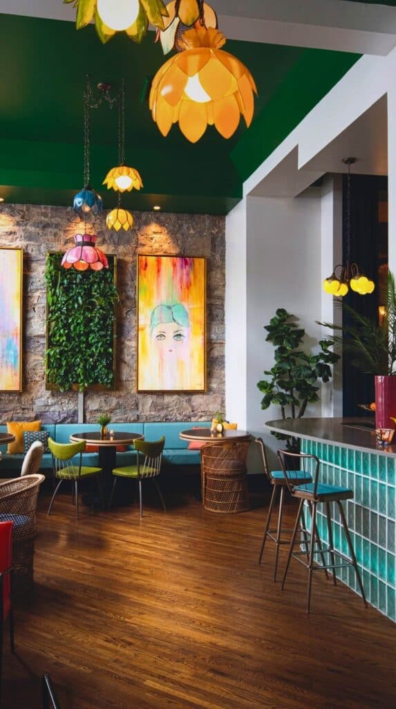 Retro-inspired lounge at The Dwell Hotel with colorful pendant lighting, bold artwork, and mid-century modern furniture in downtown Chattanooga.