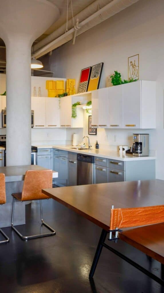 Apartment-style hotel suite kitchen and dining area at Hotel Clemons with modern cabinetry and industrial loft details.