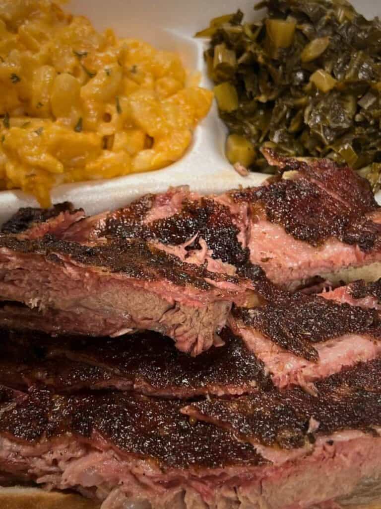 A smoked brisket plate with mac and cheese and greens at Murky Waters, a rich lunch in Ocean Springs to share.