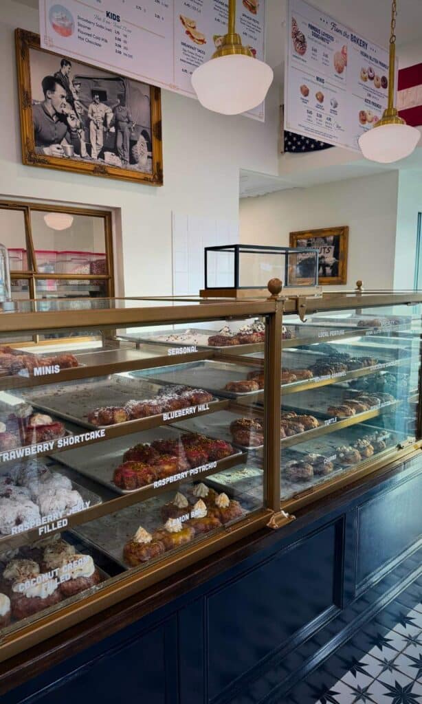 Glass display case filled with gourmet donuts inside Parlor Doughnuts, one of the best restaurants in Ocean Springs for breakfast treats.