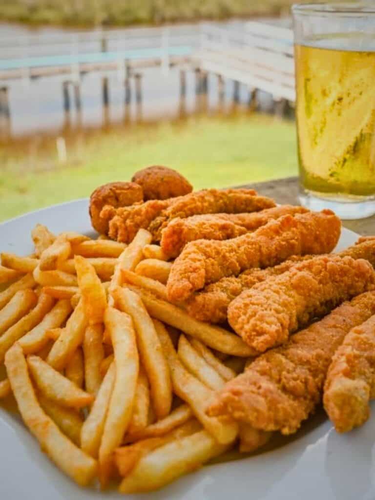 Fried seafood and fries with a cold beer at Bacchus on the Bayou, where to eat in Ocean Springs right on the water.