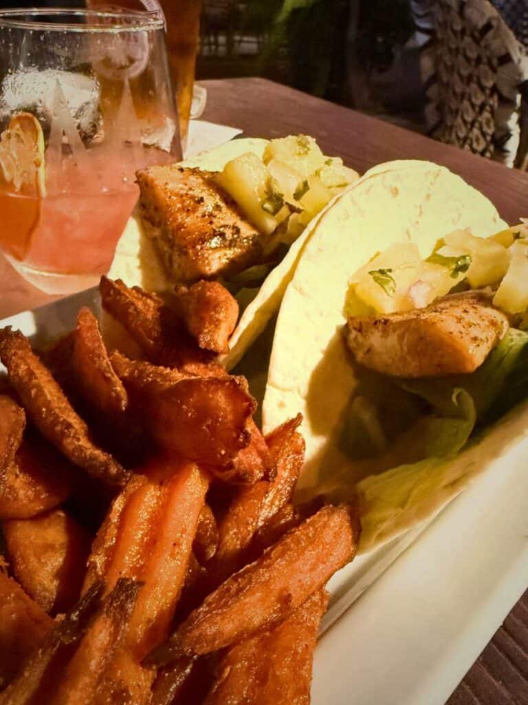 Plate of mahi tacos topped with fresh ingredients and sauce, representing small plates at a downtown Ocean Springs restaurant.