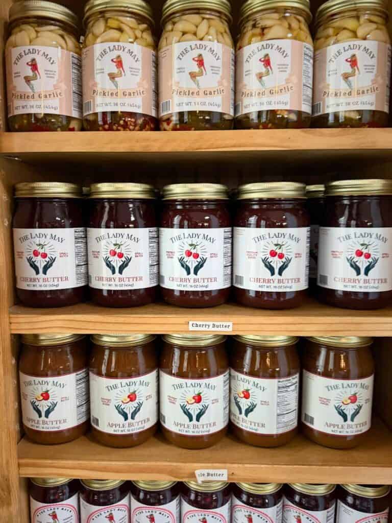 Jars of pickled garlic and cherry butter at May's Market, a sweet stop for where to eat in Ocean Springs, MS shoppers.