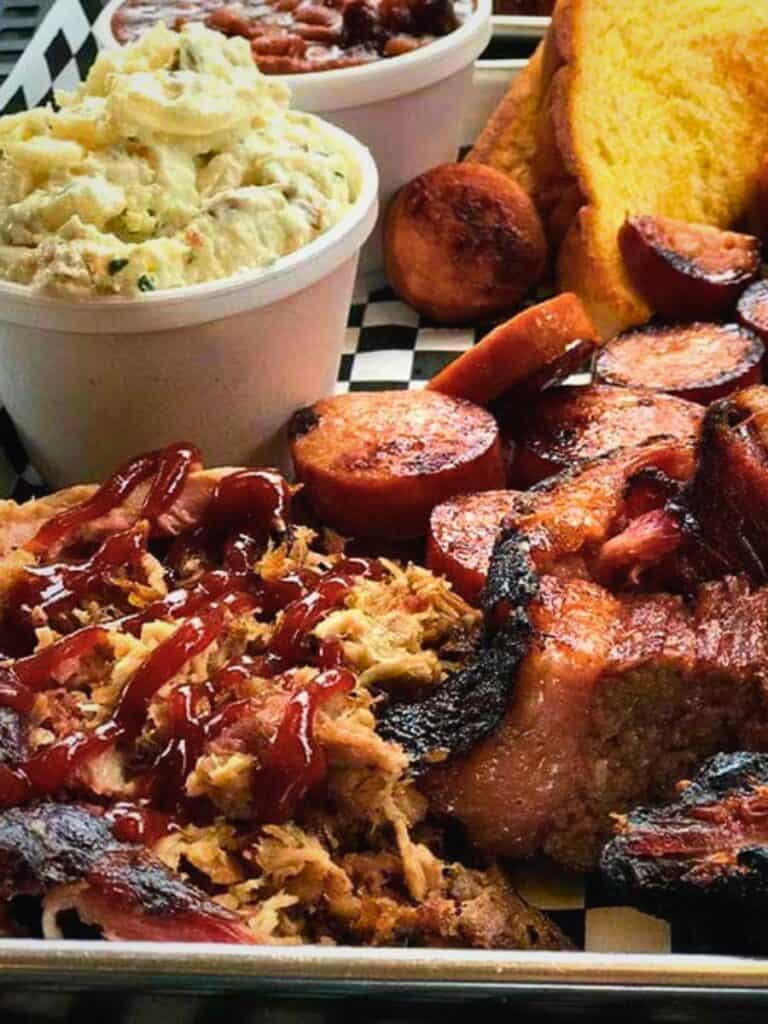 A loaded platter of pulled pork and sausage at Murky Waters, where to eat in Ocean Springs, MS right downtown.