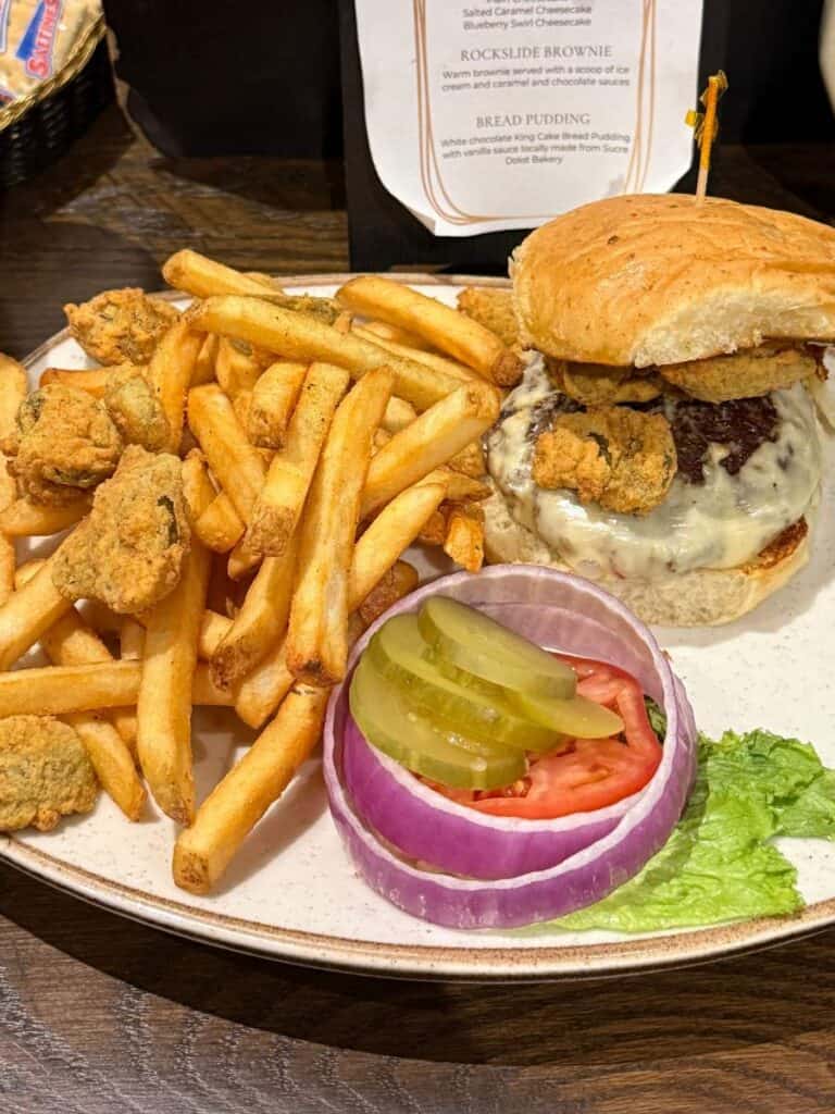 Gourmet burger stacked with toppings on a bun, showcasing elevated bar food at one of the best restaurants in Ocean Springs.