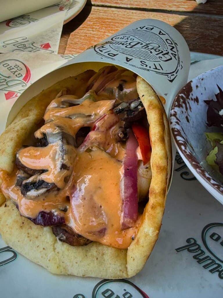 Close up of a surf and turf gyro stuffed with meat, vegetables, and creamy sauce in pita bread, highlighting a unique option among Ocean Springs Mississippi restaurants.