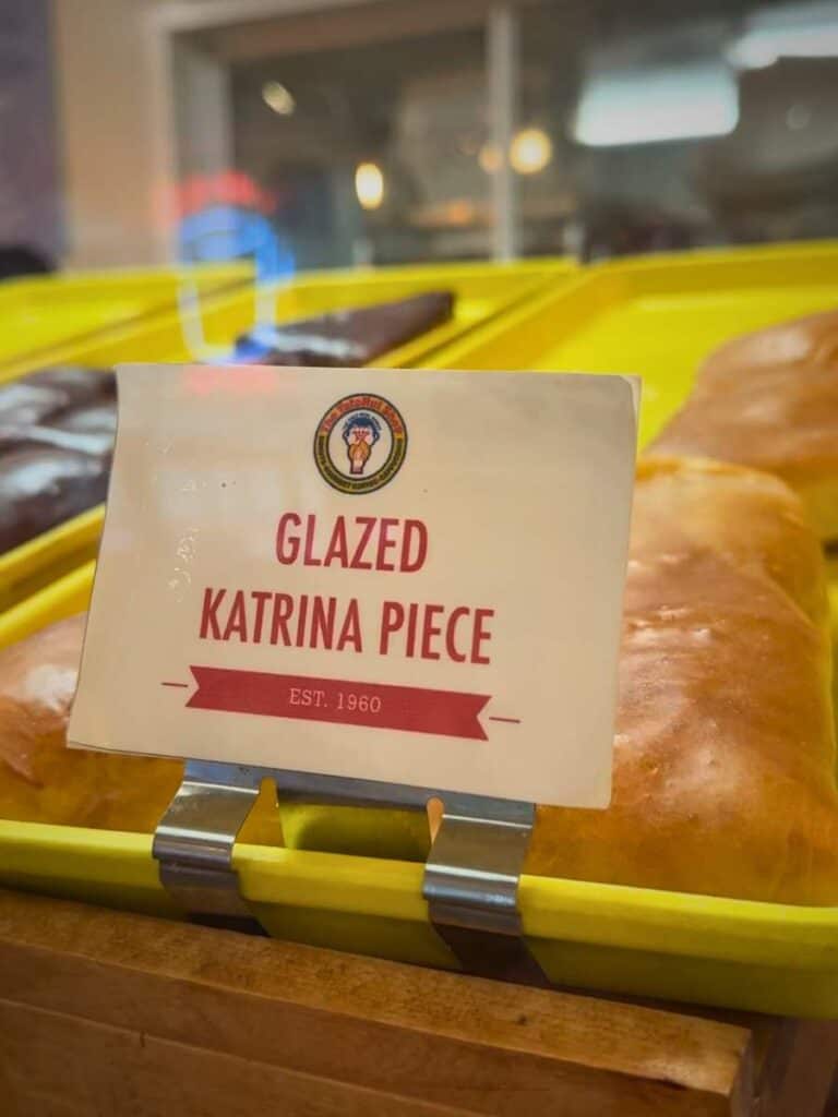 A Glazed Katrina Piece sign on fresh dough at Tatonut, one of the tastiest Ocean Springs restaurants for donuts.