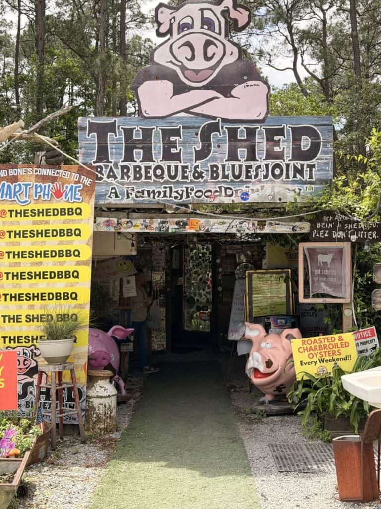 Entrance to The Shed Barbeque and Blues Joint with rustic signage and eclectic decor, a well known dining spot near Ocean Springs MS.