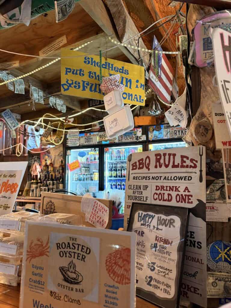 Walls packed with vintage items, signs, and collectibles creating a chaotic but fun interior at a barbecue restaurant in Ocean Springs.