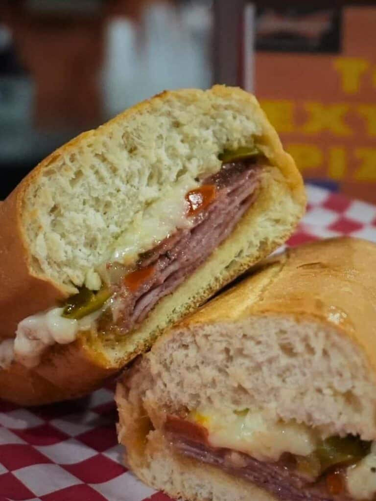 A pressed sandwich stuffed with meats and peppers at Tom's, a hearty choice for lunch in Ocean Springs to grab and go.
