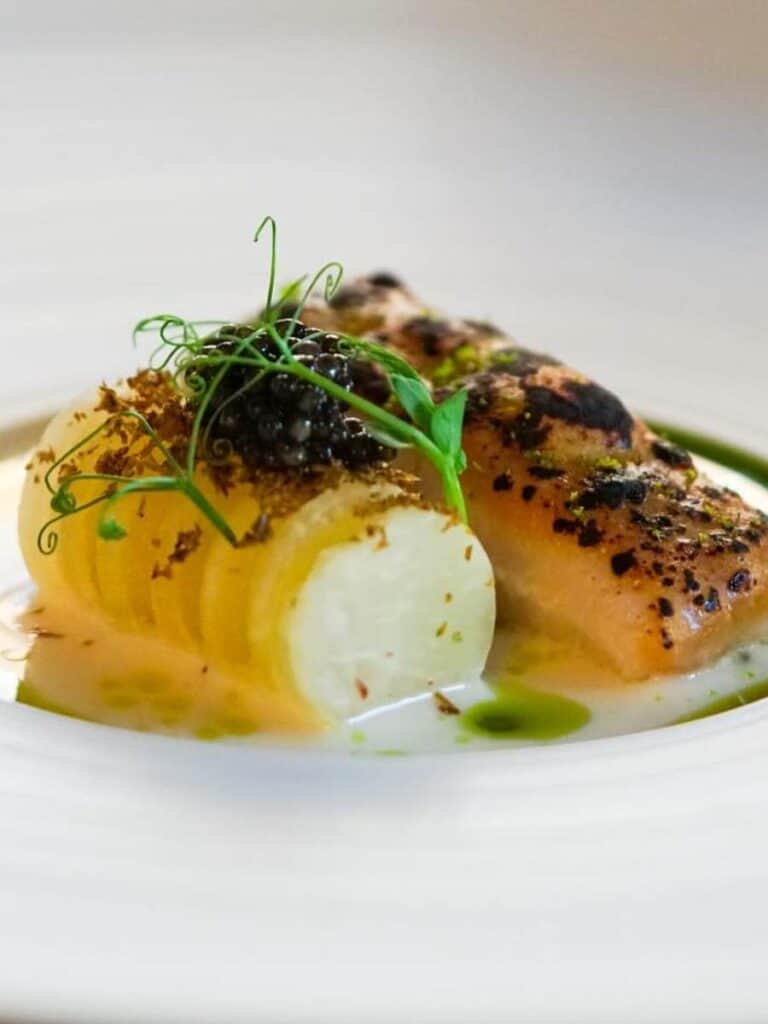 A composed salmon course with caviar and pea shoots at Vestige, the splurge among places to eat in Ocean Springs, MS at night.