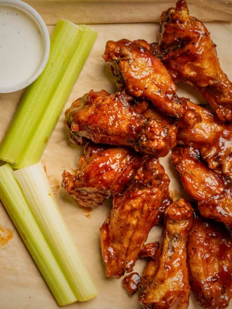 Saucy BBQ wings with celery and ranch, a shareable starter at the Best places to eat in Ocean Springs, MS for barbecue.
