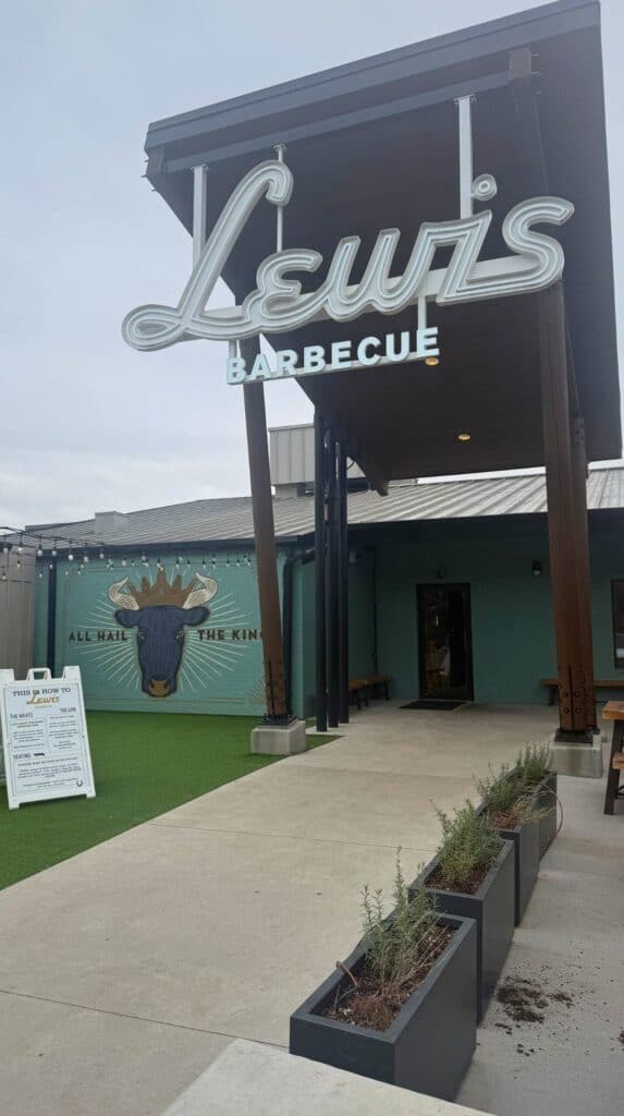 Entrance to Lewis Barbecue in Greenville SC with a large retro style “Lewis Barbecue” sign above the outdoor walkway.