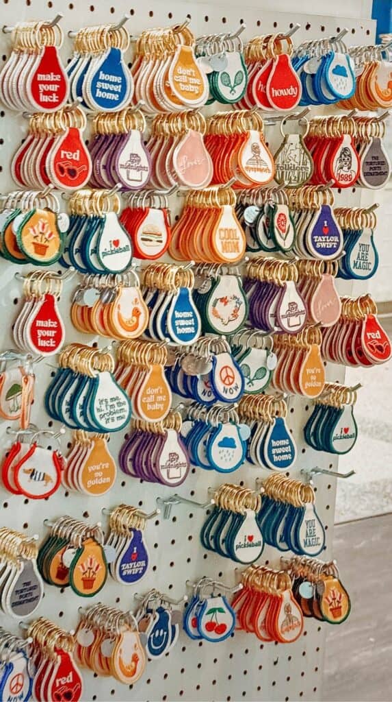 Wall display of colorful motel style keychains arranged in rows inside the gift section at M. Judson Booksellers.