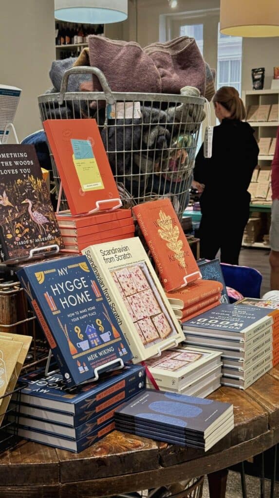 Wooden floor and cozy interior inside M. Judson Booksellers with curated book displays and bright natural light from large courthouse windows.