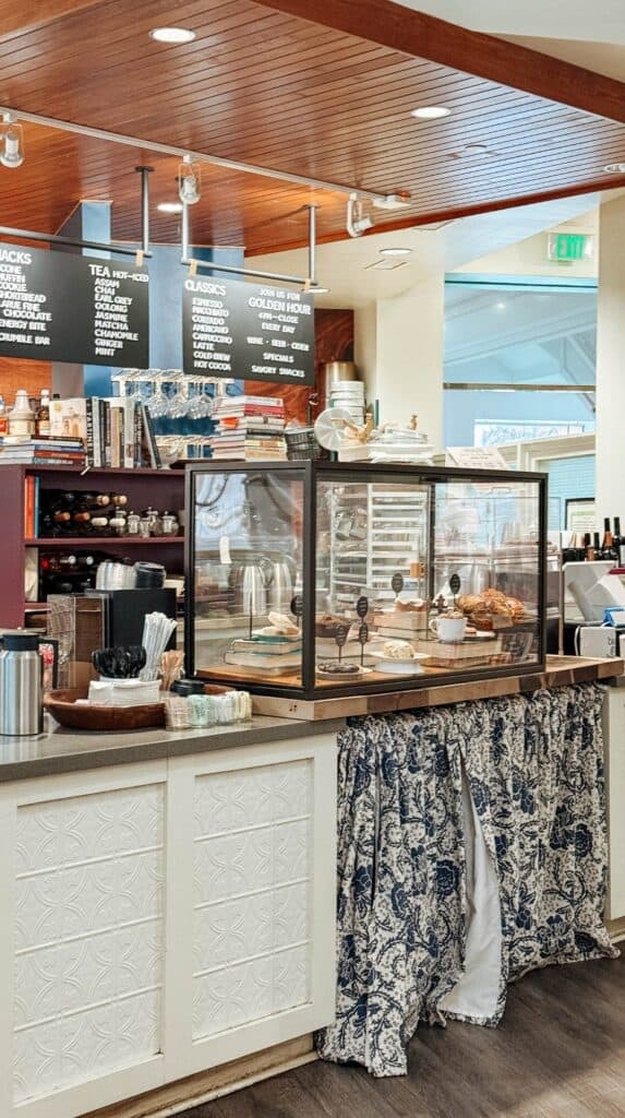 Cafe counter inside Camilla Kitchen at M. Judson Booksellers with books stacked decoratively across the front of the register area.