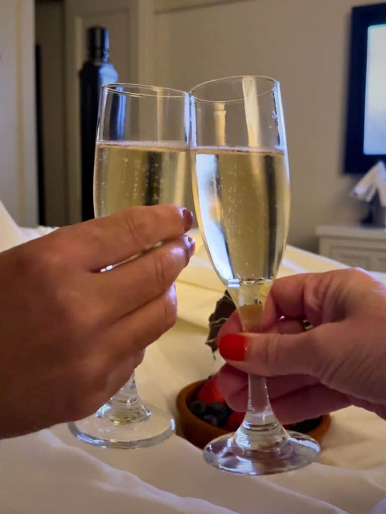 An anniversary champagne toast at Hotel Emma San Antonio with two flutes clinking over fresh berries