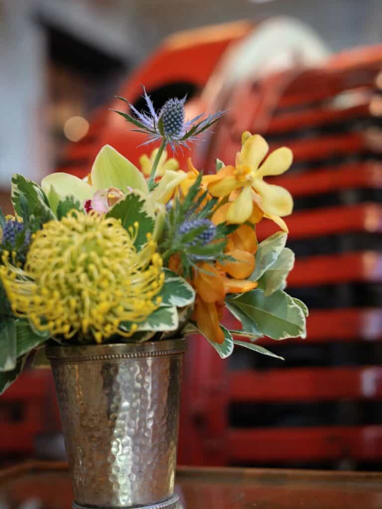 Floral arrangement in a silver cup at Hotel Emma San Antonio, set before a vintage red delivery truck