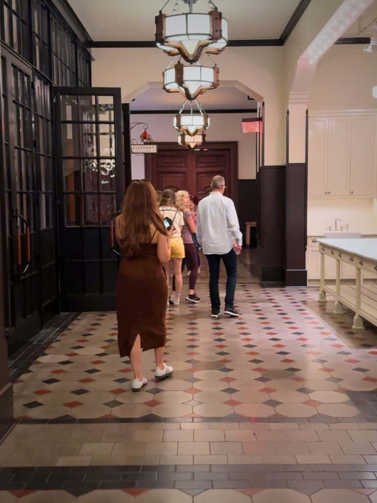 Guests on the Hotel Emma history tour walking through a tiled hallway past the old kitchen