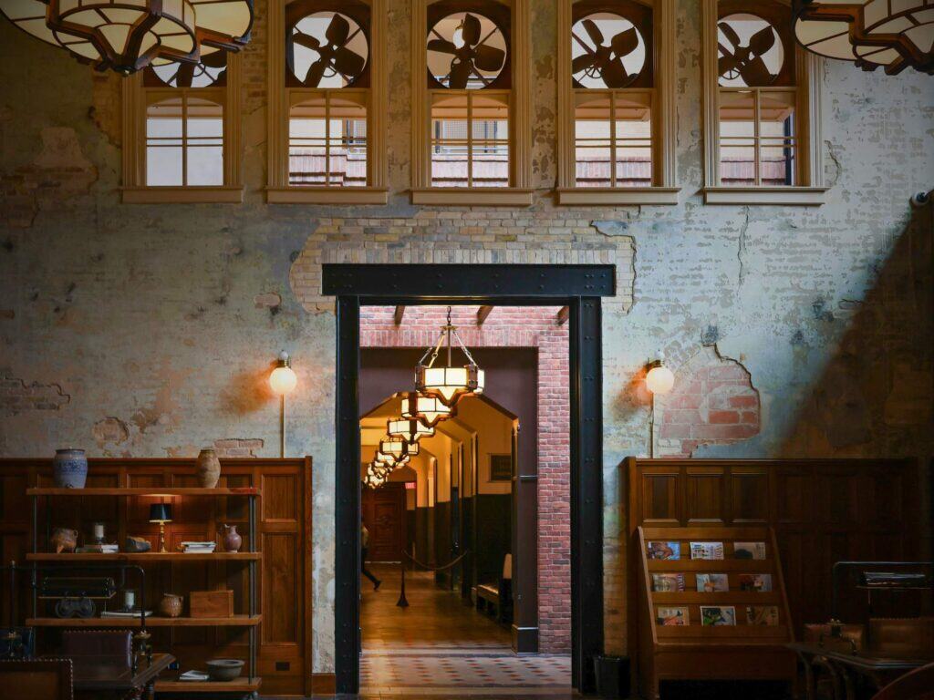 Brick doorway framed by industrial fans and wood shelves showcasing the Hotel Emma San Antonio design