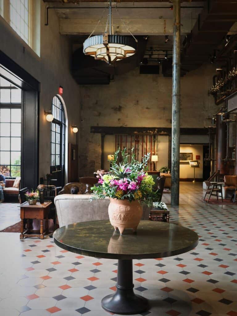 Fresh flowers on a marble table in the lobby that Hotel Emma reviews often mention, over checkered tile