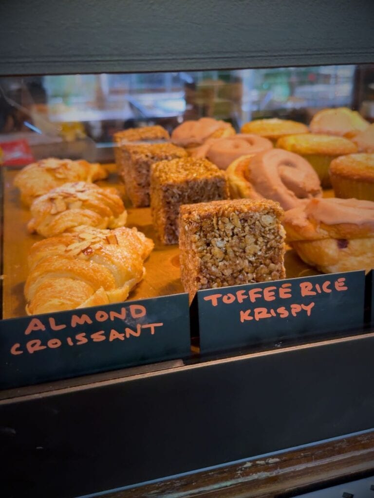 Pastry case at Larder inside Hotel Emma with almond croissants and toffee rice krispy treats
