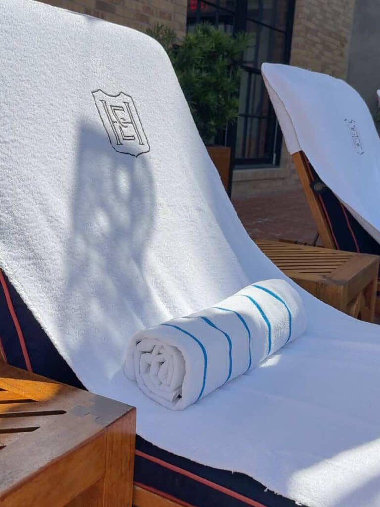 Poolside lounge chairs with monogrammed Hotel Emma towels on the third-floor terrace