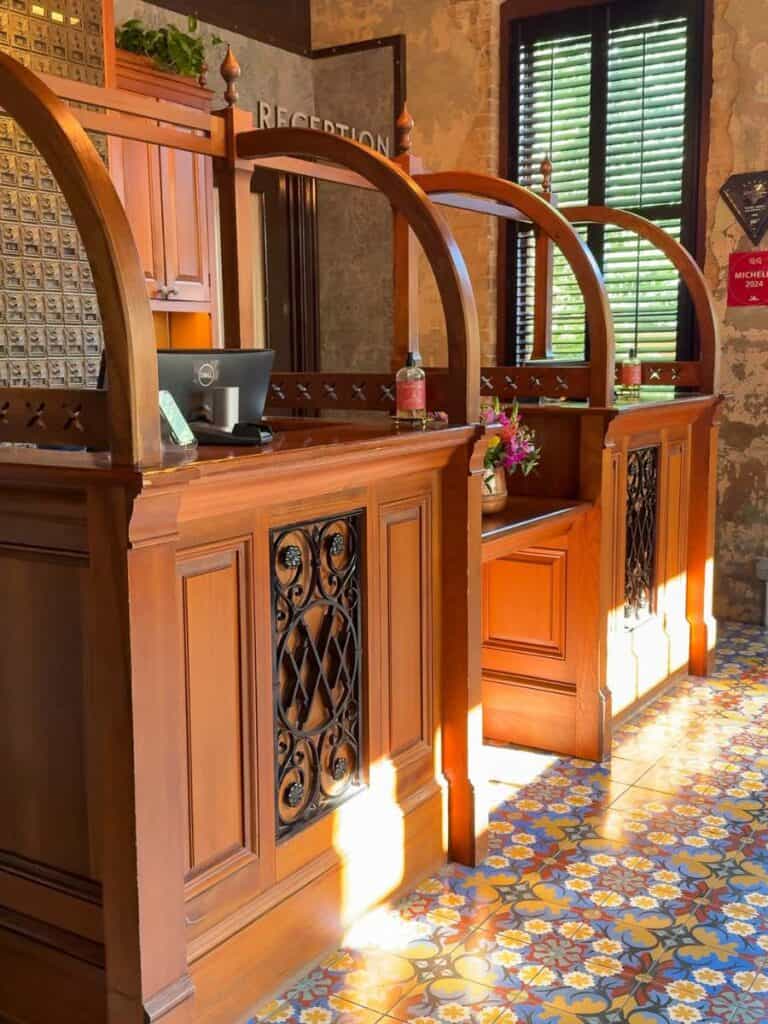 Carved wood reception desk at Hotel Emma set above colorful patterned Spanish floor tiles
