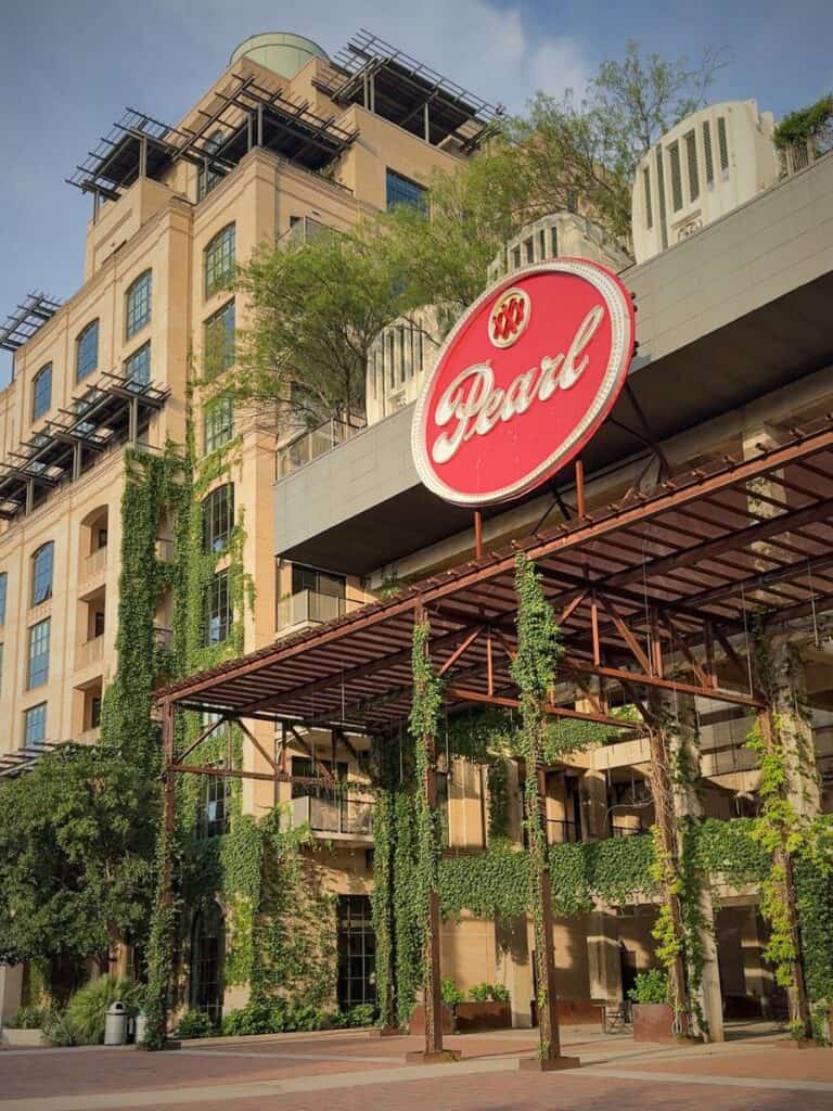 The ivy-covered Pearl building and red Pearl sign near Hotel Emma sit in the walkable Pearl District