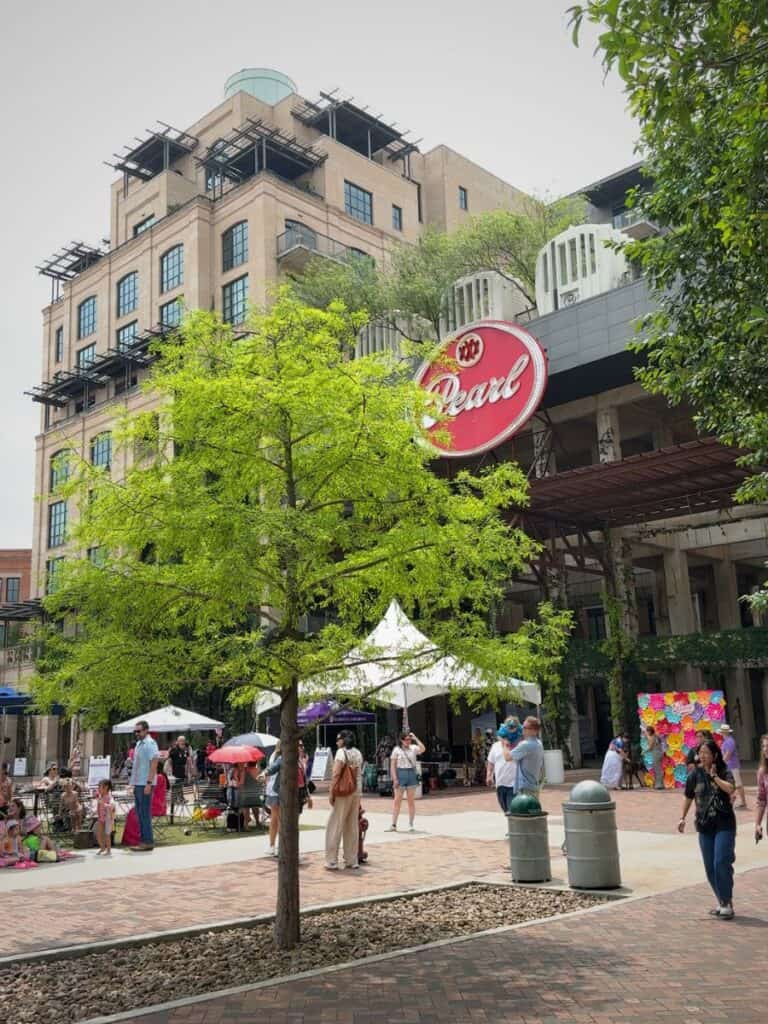 The Pearl District plaza near Hotel Emma San Antonio with the red Pearl sign and Fiesta crowds