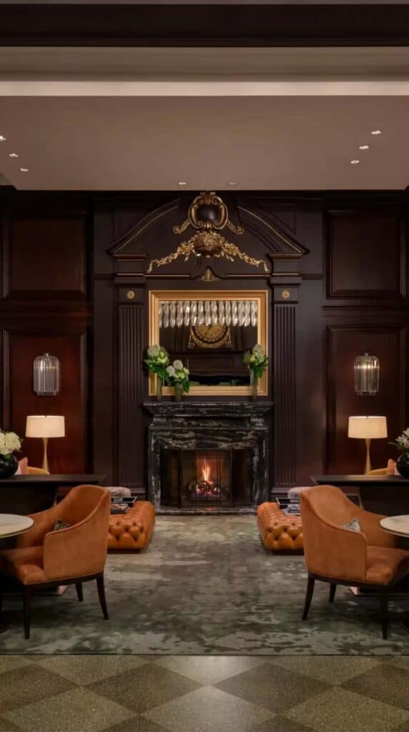 cozy lounge with fireplace, leather chairs, and dark wood interiors at Rosewood Hotel Georgia in Vancouver.