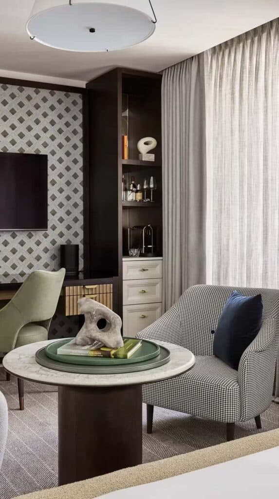 Modern hotel suite with seating area, desk, and patterned wall at Rosewood Hotel Georgia in downtown Vancouver.